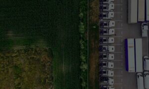 aerial view of crop field and trucks for food transport